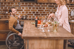 A man in a wheelchair and his wife cook dinner